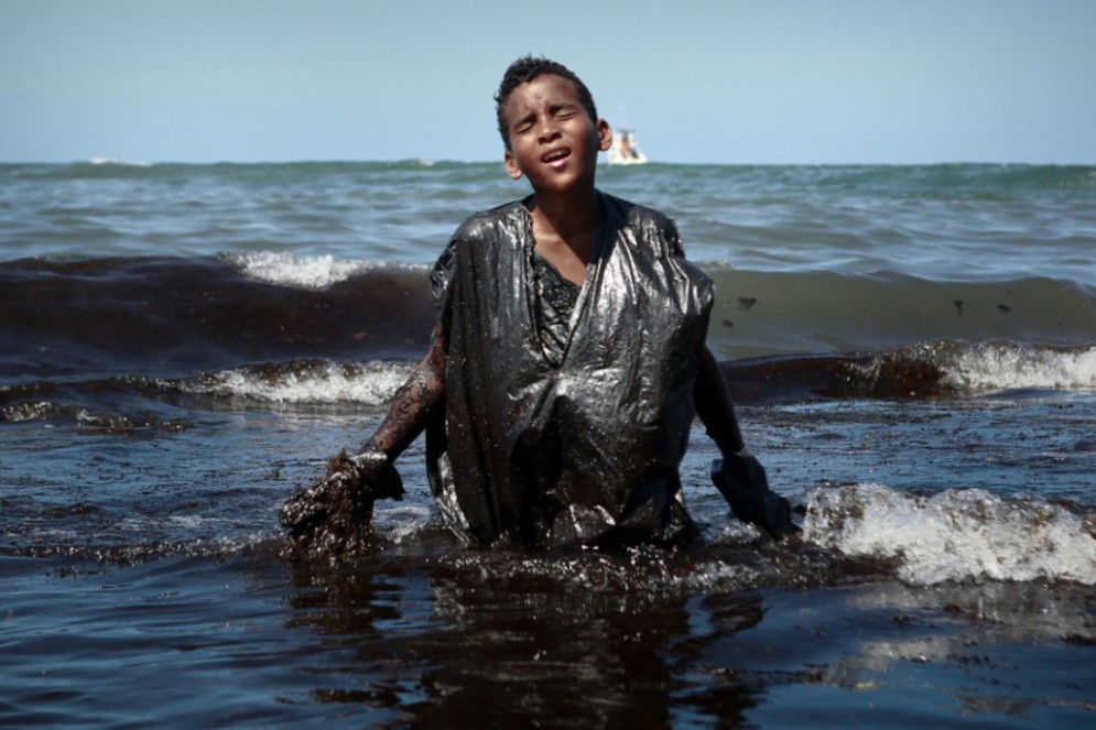 Em 2019, durante vazamento de petróleo no litoral nordestino, Everton Miguel dos Anjos, de 13 anos, ajudou na retirada dos resíduos(Foto: Leo Malafaia / AFP)