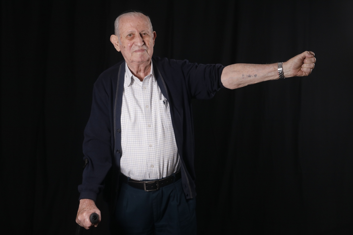 Avraham Gershon Binet mostra seu braço marcado na prisão de Auschwitz(Foto: MENAHEM KAHANA/AFP)