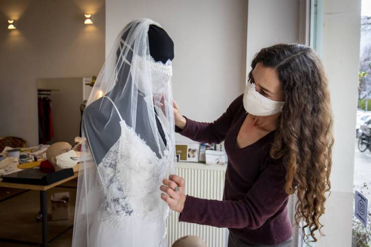 Estilista Friederike Jorzig ajusta modelo de noiva com máscara 