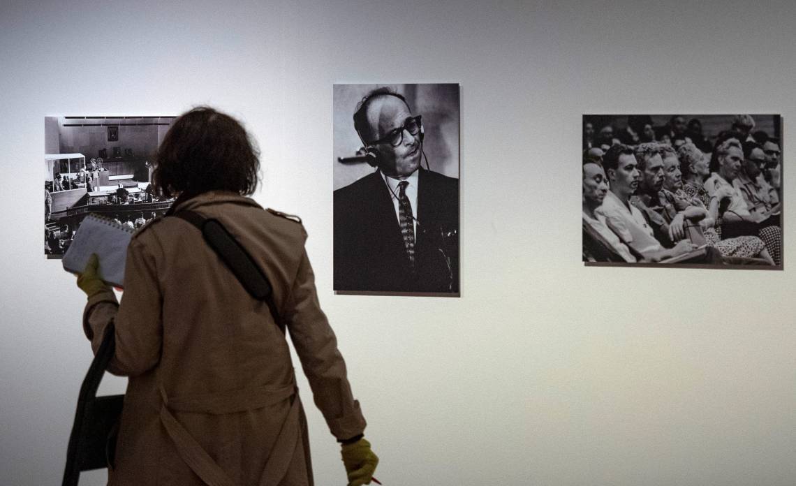 Um visitante passa por um retrato do criminoso de guerra nazista Adolf Eichmann (C) durante seu julgamento em Jerusalém, em uma exposição sobre a filósofa germano-americana Hannah Arendt, chamada Hannah Arendt e o século XX no Museu Histórico Alemão (Deutsches Historisches Museum - DHM) em Berlim, em 6 de maio de 2020. A exposição tem como objetivo traçar as observações de Arendt sobre a história contemporânea sobre, entre outros temas, totalitarismo, anti-semitismo, situação dos refugiados e Julgamento de Eichmann em Jerusalém(Foto: JOHN MACDOUGALL / AFP)