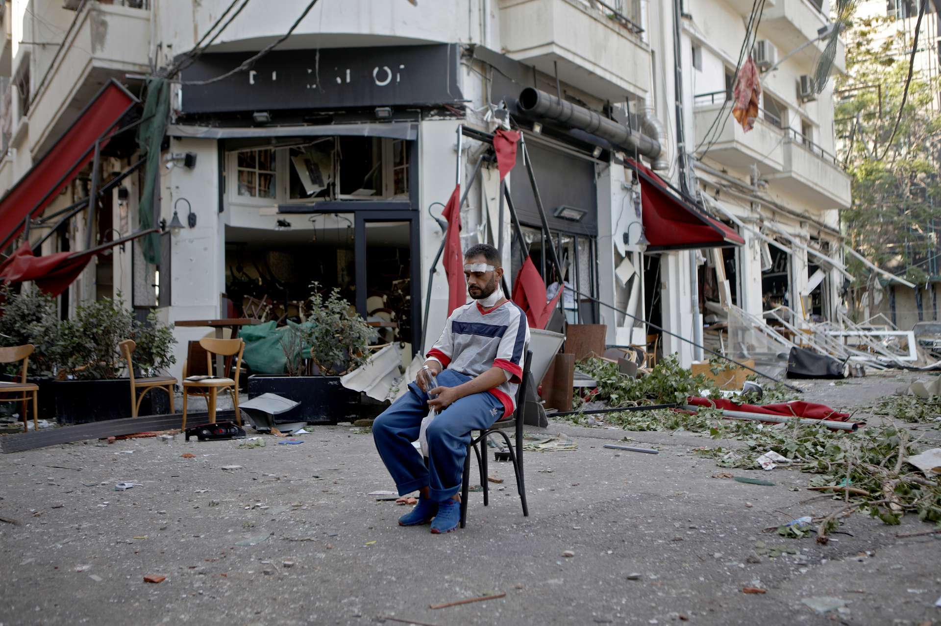 ￼HOMEM ferido senta-se ao lado de um restaurante no moderno bairro parcialmente destruído de Mar Mikhael, em Beirute (Foto: Foto de PATRICK BAZ / AFP)