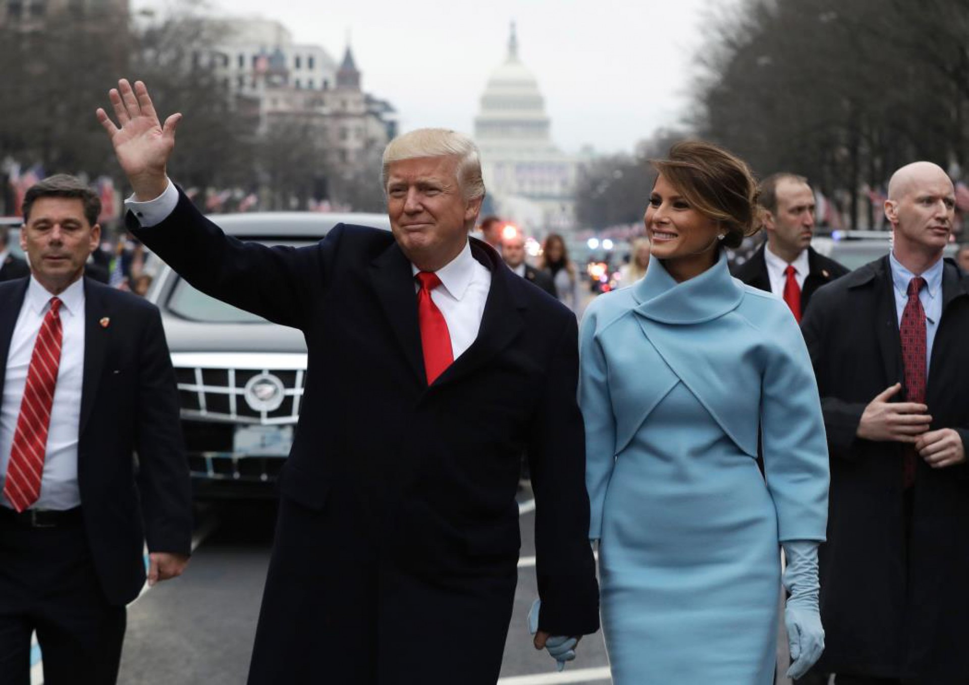 O presidente Donald Trump acena enquanto caminha com a primeira-dama Melania Trump (Foto: EVAN VUCCI/AFP)