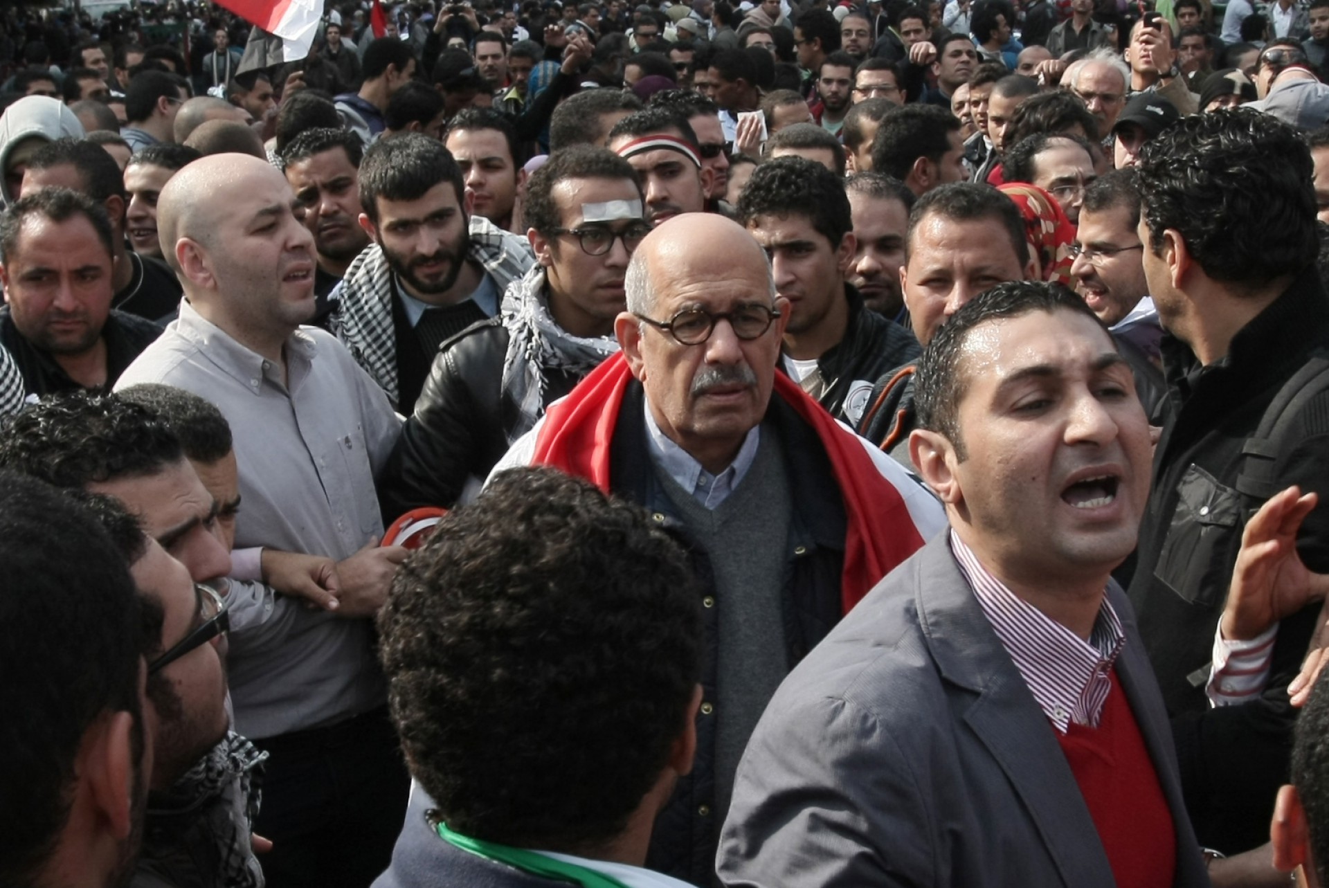 (ARQUIVOS) Nesta foto de arquivo tirada em 25 de novembro de 2011, o ex-chefe da vigilância nuclear egípcia da ONU e candidato à presidência Mohamed ElBaradei (C), com uma bandeira nacional nos ombros, se junta a milhares de manifestantes na praça Tahrir, no Cairo, para apelar à decisão militares para entregar o poder a um governo de salvação nacional. - Dez anos atrás, quando protestos explodiram em todo o mundo árabe, os governos ocidentais falharam em cumprir um compromisso com o destino e ajudar a alimentar sonhos de democracia, perdendo uma chance sem precedentes de moldar uma reforma real. A história não os julgará com gentileza, dizem muitos dos que estiveram lá e conversaram com a AFP no 10º aniversário da Primavera Árabe, sobre por que uma década após sua promessa inicial murchou e quase morreu. (Foto de Mahmud Hams / AFP)