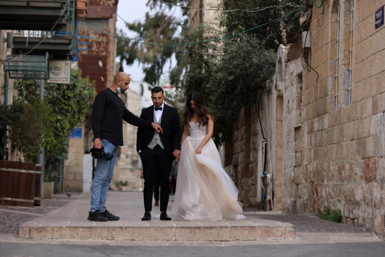Fotógrafo de casamento prepara casal para fotos em Jesuralém