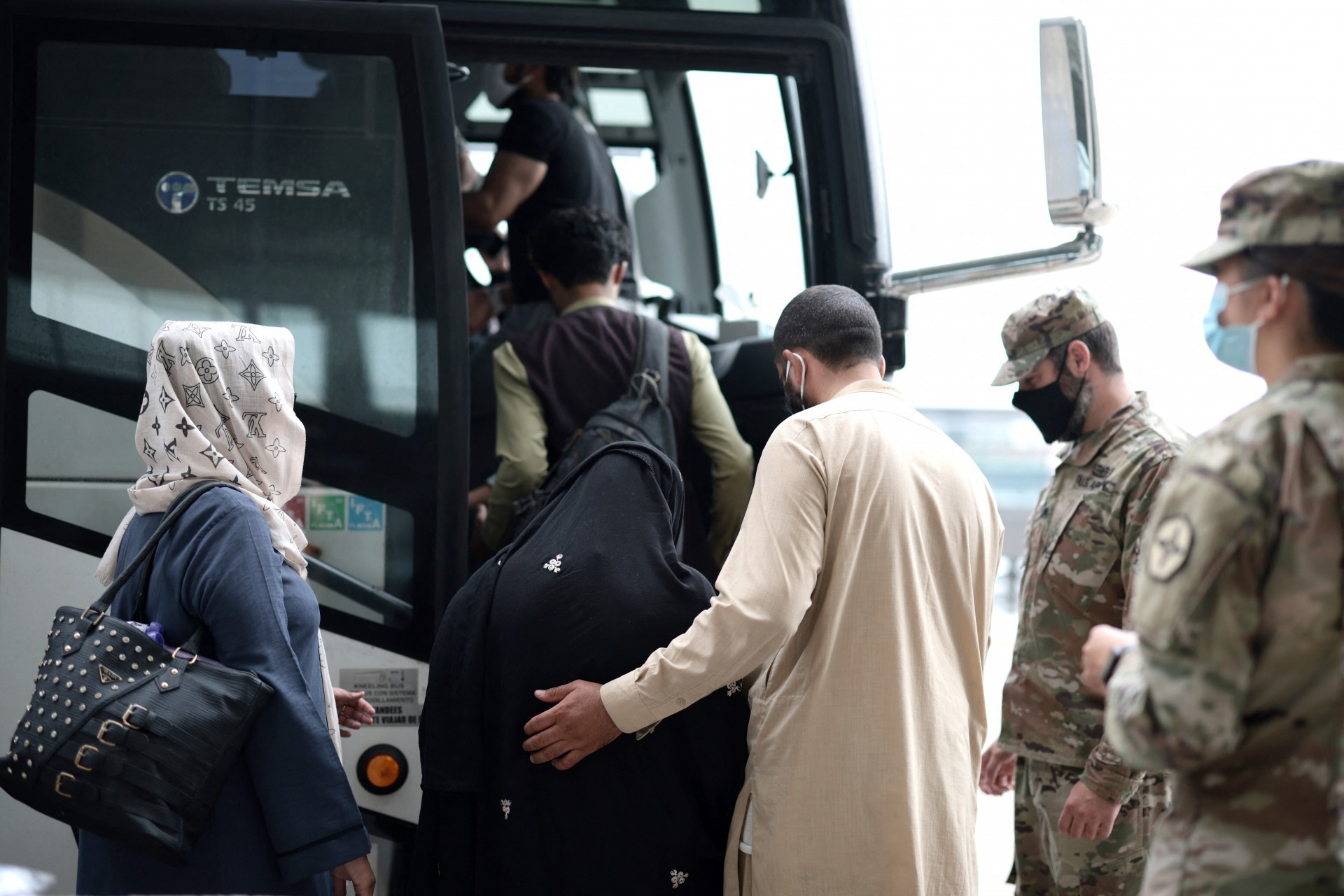 DULLES, VIRGÍNIA - 31 DE AGOSTO: Refugiados embarcam em um ônibus no Aeroporto Internacional de Dulles que os levará a um centro de processamento de refugiados após serem evacuados de Cabul após a tomada do Talibã no Afeganistão em 31 de agosto de 2021. O Departamento de Defesa anunciou ontem que os militares dos EUA concluíram sua retirada do Afeganistão, encerrando 20 anos de guerra. Anna Moneymaker / Getty Images / AFP(Foto: Anna Moneymaker / GETTY IMAGES NORTH AMERICA / Getty Images via AFP)