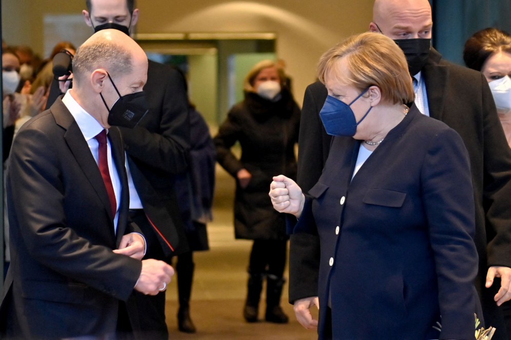 Olaf Scholz e Angela Merkel se cumprimentam(Foto: John MACDOUGALL / AFP)