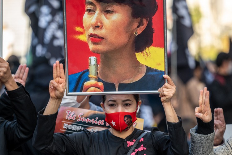 Um ativista pró-democracia segura uma imagem do líder civil deposto de Mianmar, Aung San Suu Kyi, enquanto eles participam da "Marcha pela Paz em Demonstração de Respeito pelos Direitos Humanos na Ásia" em Tóquio em 11 de dezembro de 2021.(Foto: Foto de Philip FONG / AFP)