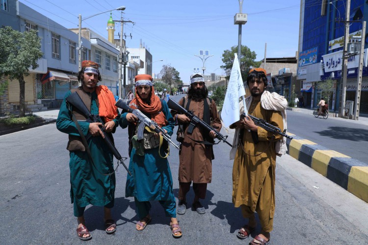 Os combatentes do Talibã montam guarda ao longo de uma estrada perto do local de uma procissão da Ashura, realizada para marcar a morte do Imam Hussein, neto do Profeta Maomé, ao longo de uma estrada em Herat em 19 de agosto de 2021, durante a tomada militar do Talibã no Afeganistão. (Foto: AREF KARIMI / AFP)