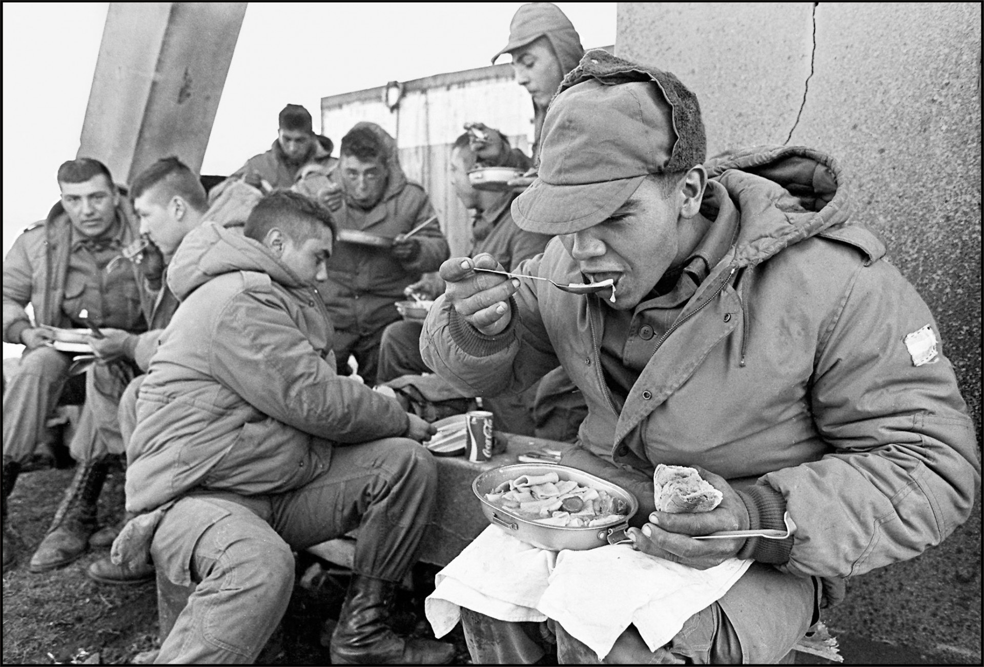 Nesta foto de arquivo tirada em 13 de abril de 1982, soldados argentinos almoçam na antiga base da Marinha Real parcialmente destruída(Foto: Daniel Garcia/AFP)