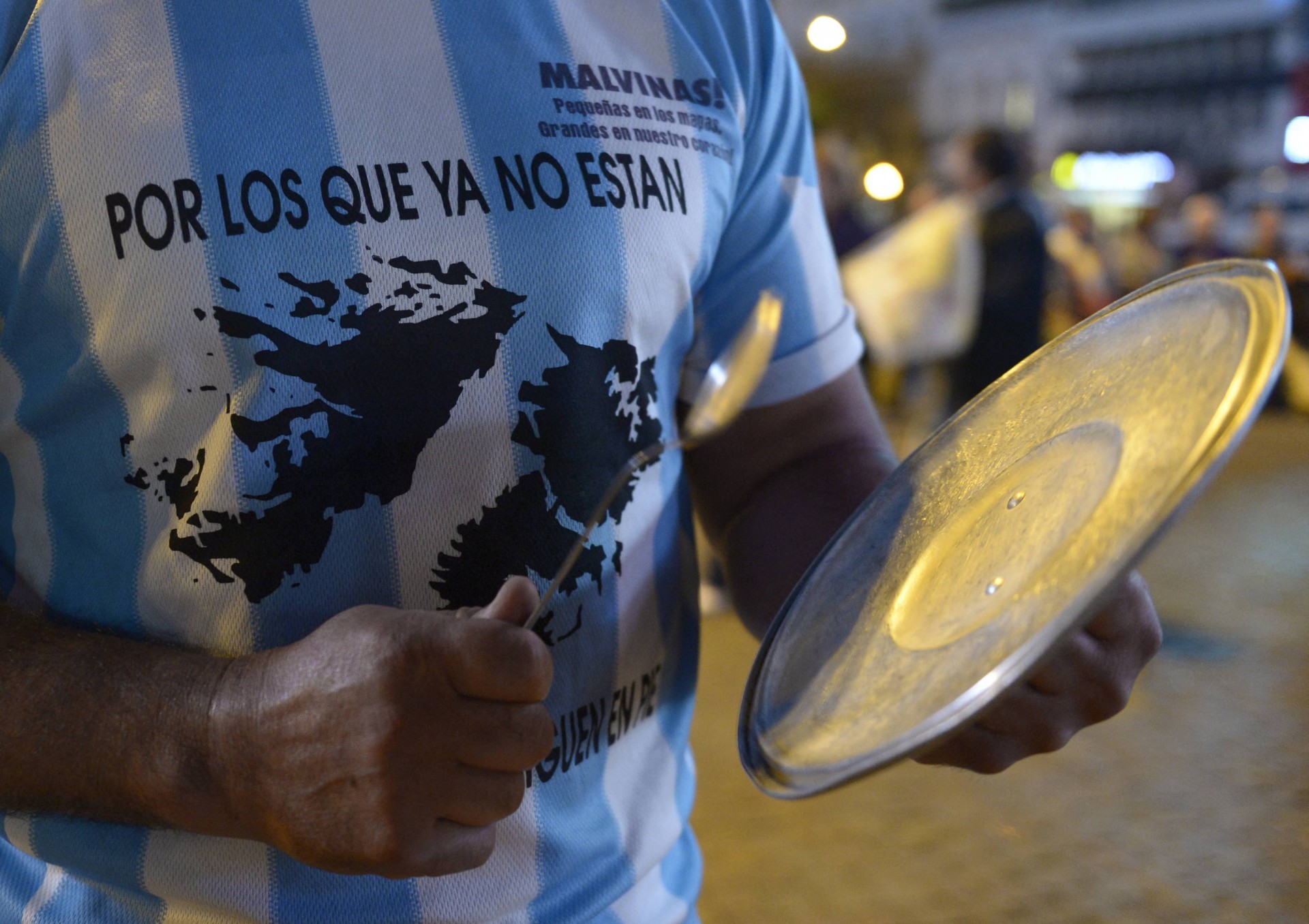 Nesta foto de arquivo tirada em 18 de abril de 2013, um homem vestindo uma camiseta com o mapa das Ilhas Malvinas lendo "Para aqueles que não estão aqui", bate uma panela durante um protesto contra o governo da presidente argentina Cristina Fernández de Kirchner em Buenos Aires(Foto: JUAN MABROMATA / AFP)