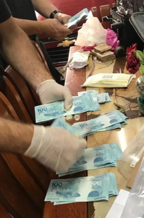 Contagem de dinheiro apreendido na casa de suspeitos de fraude milionária na previdência social, em Fortaleza. Crimes teriam ocorrido entre 2012 e 2019(Foto: Divulgação / Polícia Federal)