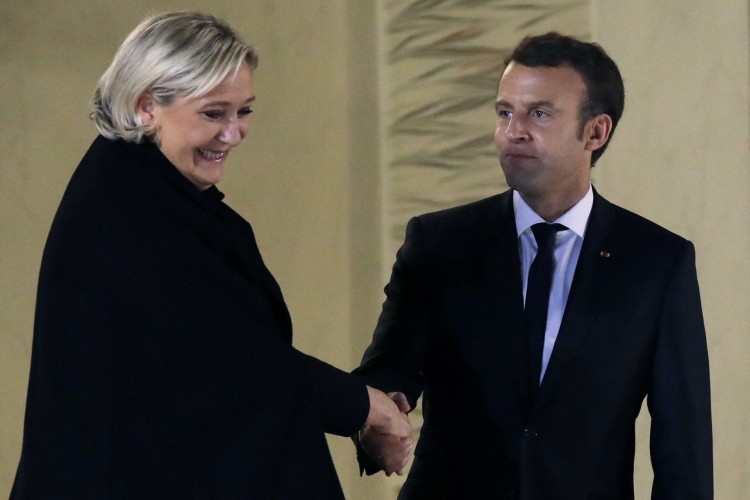 (ARQUIVOS) Nesta foto de arquivo tirada em 21 de novembro de 2017, a extrema-direita francesa Rassemblement National (RN), anteriormente conhecida como Front National (FN), a presidente do partido Marine Le Pen (E) aperta a mão do presidente francês Emmanuel Macron após sua reunião no palácio do Eliseu em Paris(Foto: LUDOVIC MARIN / AFP)