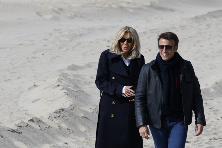 O presidente francês e candidato do partido La Republique en Marche (LREM) à reeleição Emmanuel Macron e sua esposa Brigitte Macron encontram pessoas durante uma caminhada em uma praia depois que ele votou no primeiro turno da eleição presidencial da França em uma estação de votação em Le Touquet, norte da França em 10 de abril de 2022(Foto: LUDOVIC MARIN / AFP)