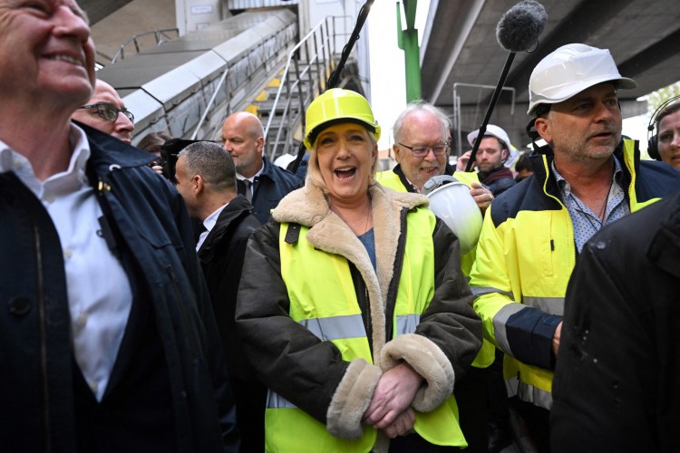 A candidata presidencial do partido de extrema direita francês Rassemblement National (RN) Marine Le Pen (C) participa com o membro do partido de extrema direita francês Rassemblement National (RN) Wallerand de Saint-Just (2º R atrás) durante uma reunião de campanha em Gennevilliers, perto Paris, em 13 de abril de 2022(Foto: EMMANUEL DUNAND / AFP)