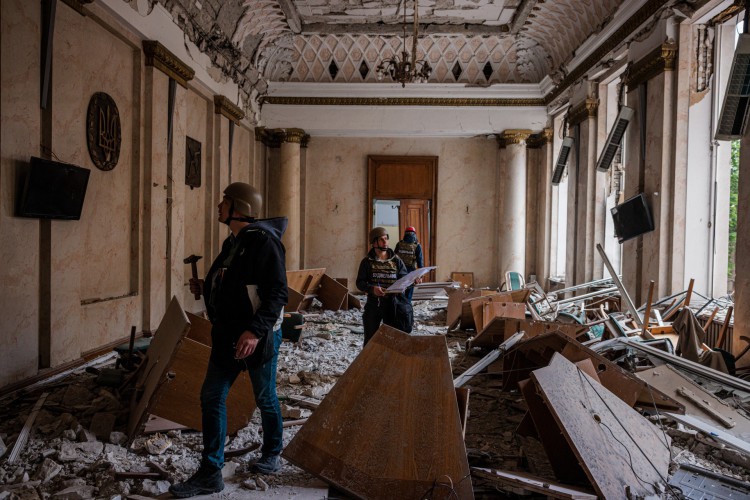 Engenheiros de construção examinam um edifício danificado da Administração Estatal Regional de Kharkiv em 16 de maio de 2022, que foi fortemente bombardeado durante a invasão russa da Ucrânia(Foto: Dimitar DILKOFF / AFP)