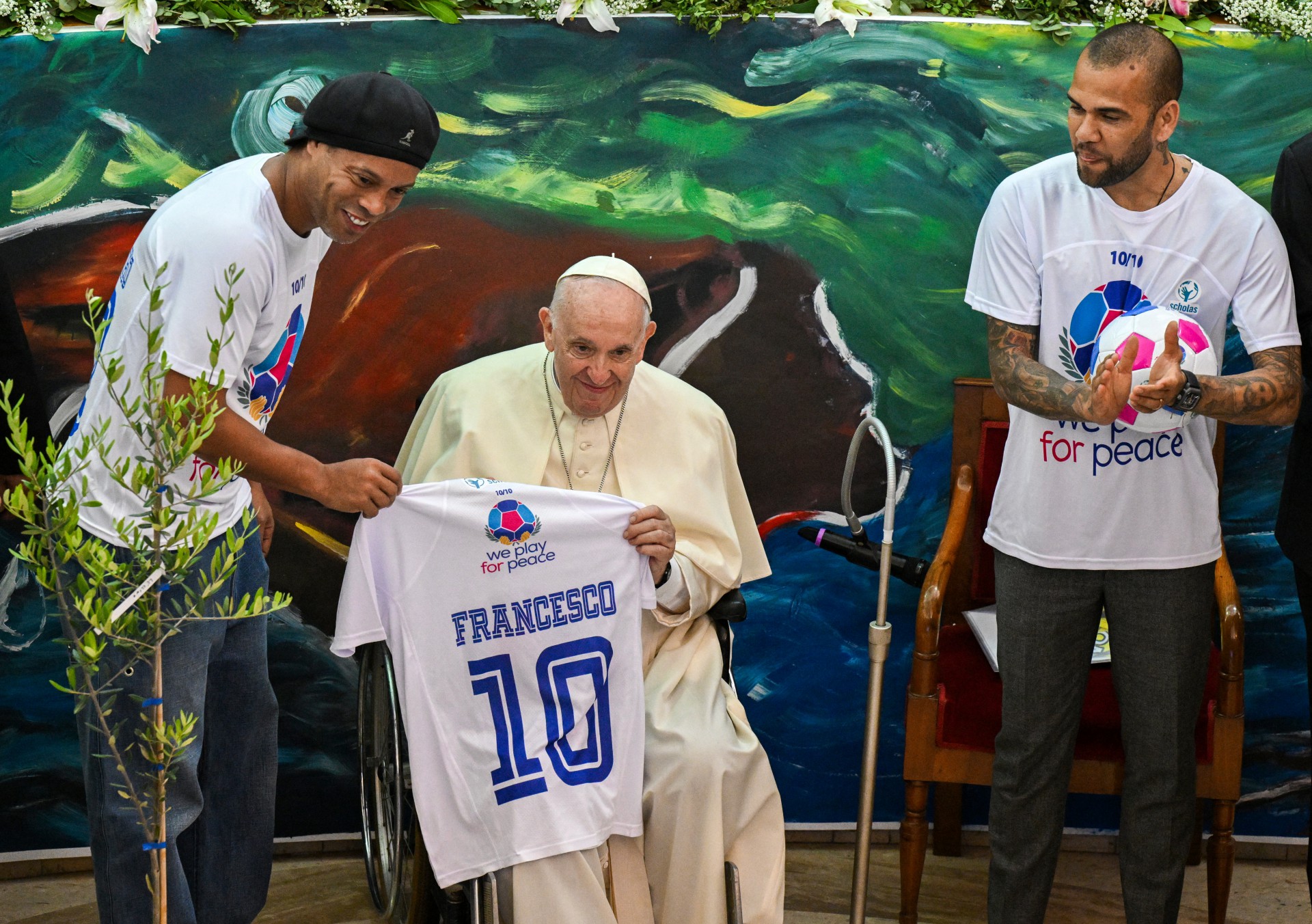 O ex-jogador de futebol brasileiro Ronaldinho (E) e o jogador de futebol brasileiro Dani Alves (D) entregam uma camisa ao Papa Francisco (Foto: Tiziana FABI / AFP)