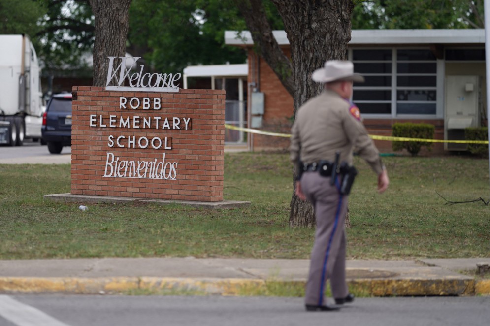 Um oficial sai da Robb Elementary School em Uvalde, Texas, em 24 de maio de 2022. Um atirador de 18 anos matou 14 crianças e um professor em uma escola primária no Texas na terça-feira, de acordo com o governador do estado. Esse foi o tiroteio escolar mais mortal em anos.