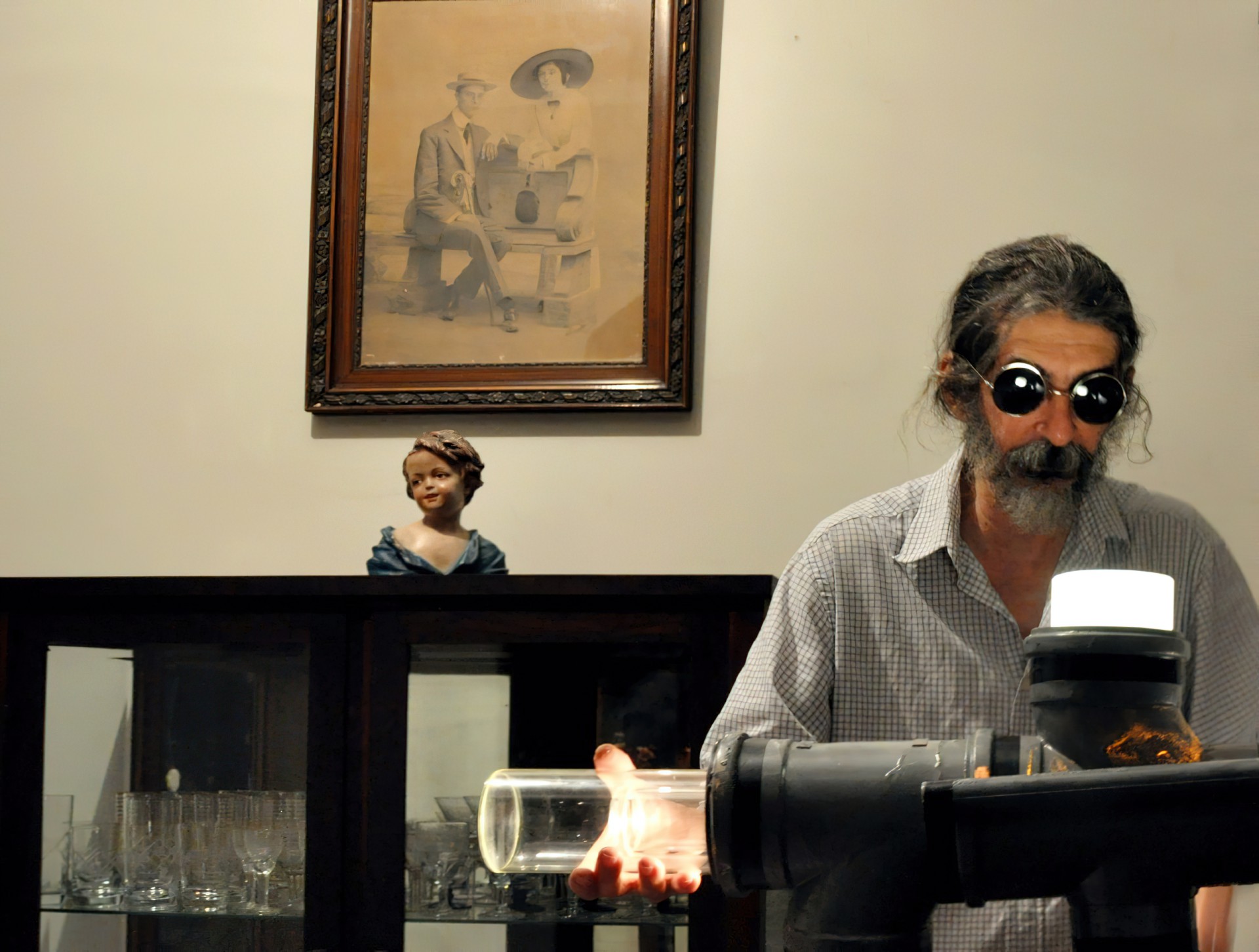 Firmino Holanda na casa que mora desde os dois anos de idade. Na fotografia, o cineasta e móvel, estatueta e quadro pertencentes aos seus avós, William Watson e Maria Gurgel (Foto: Bárbara Cariry/Acervo Firmino Holanda)