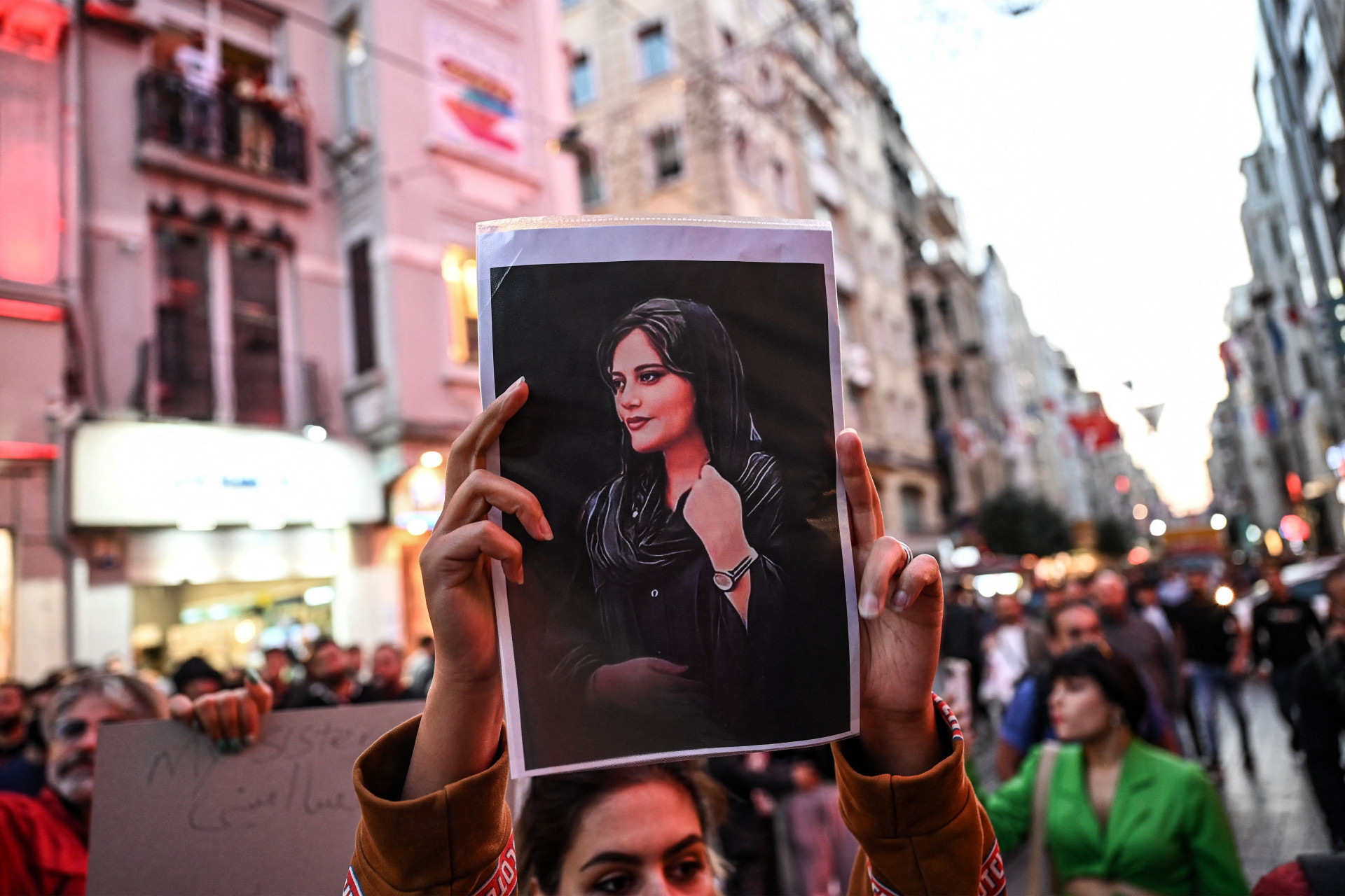 Manifestante levanta a imagem de Mahsa Amini. (AFP)