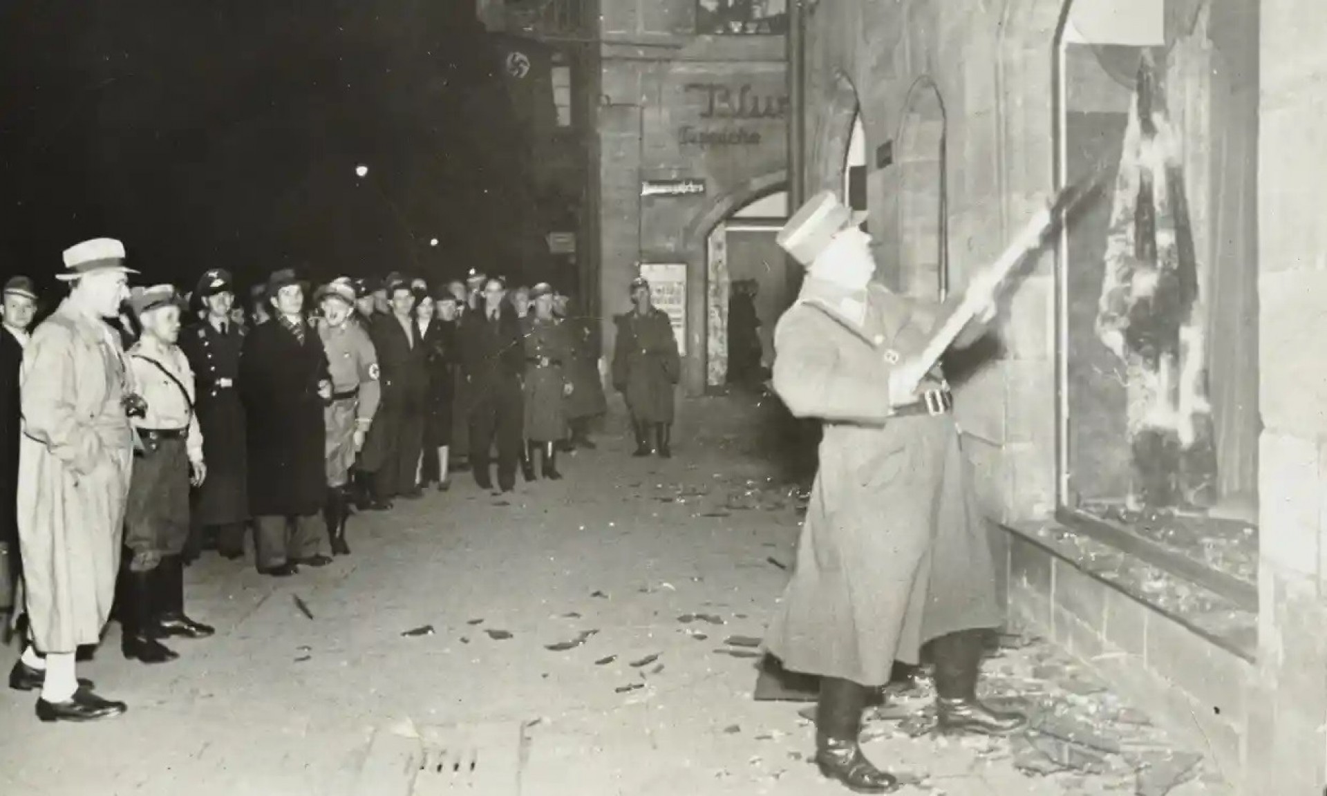 População alemã assiste vandalização das propriedades judaicas na Noite dos Cristais Quebrados. Provavelmente em Fürth, nos arredores de Nuremberg, em 10.11.1938. (Foto: Wikimedia Commons)