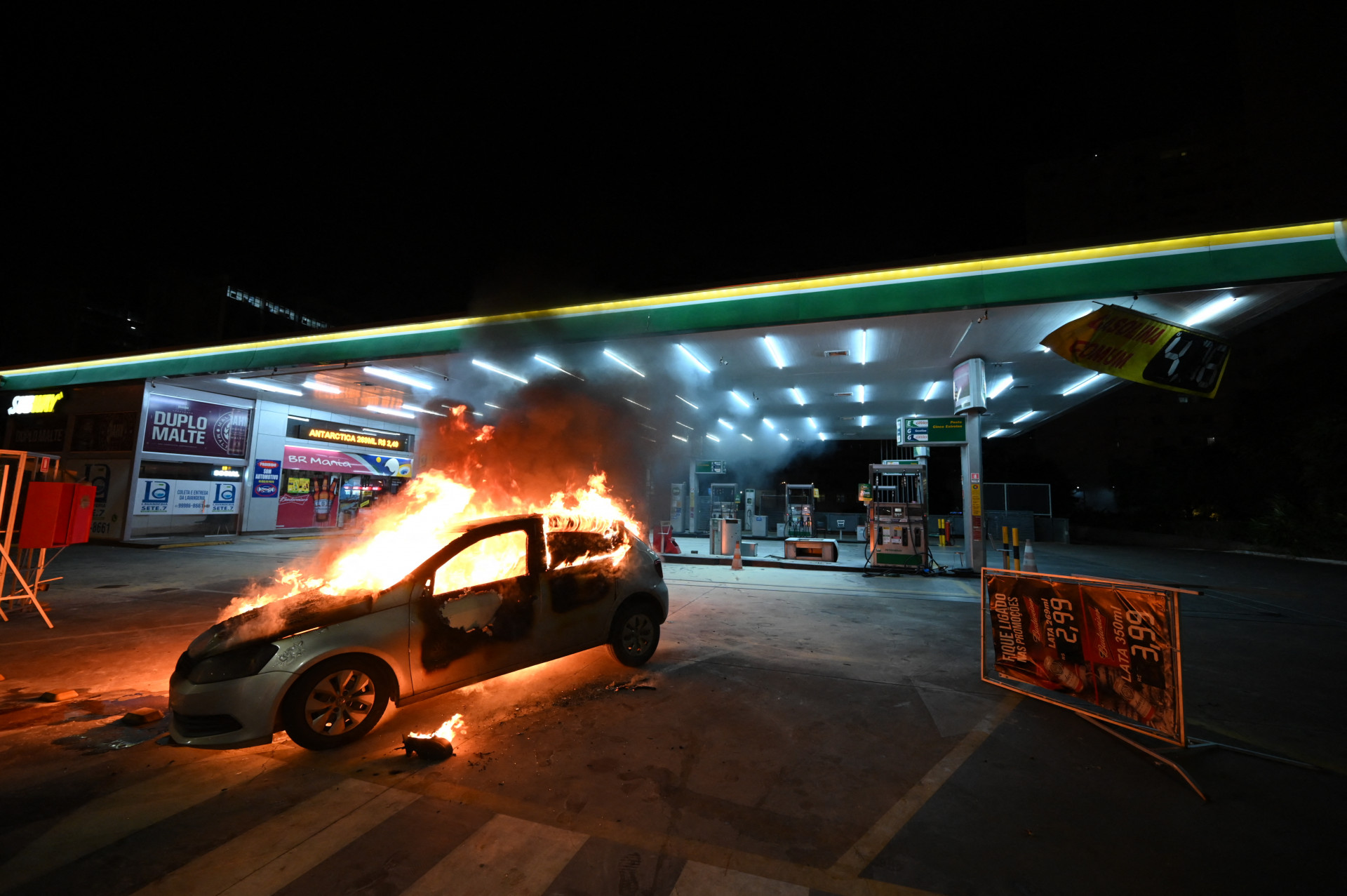 EXTREMISTAS apoiadores de Bolsonaro atearam fogo em veículos na Capital durante a noite, após a diplomação de Lula (Foto: EVARISTO SA / AFP)