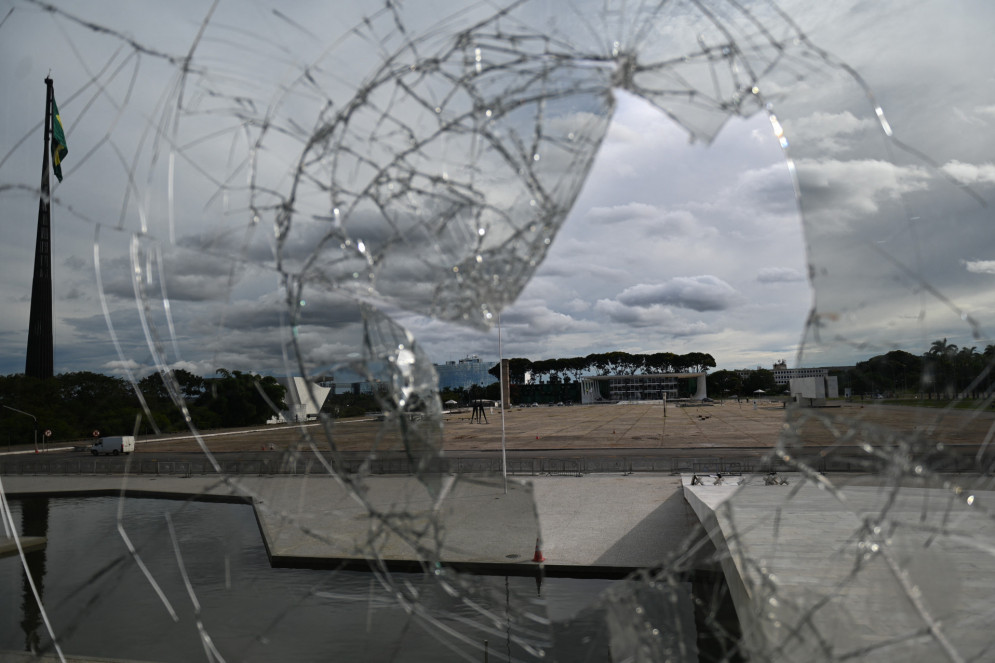 O prédio do Supremo Tribunal Federal é visto através de uma janela quebrada do Palácio do Planalto em Brasília em 9 de janeiro de 2023, um dia depois que apoiadores do ex-presidente de extrema direita Jair Bolsonaro invadiram o Congresso, o palácio presidencial e o Supremo Tribunal Federal(Foto: MAURO PIMENTEL / AFP)