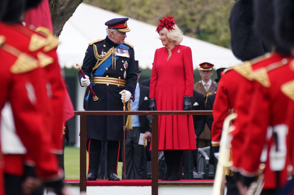 O rei Charles III da Grã-Bretanha (esquerda) e a rainha consorte britânica Camilla (direita) participam de uma cerimônia para apresentar os novos estandartes e cores a integrantes das Forças Armadas no Palácio de Buckingham, em Londres, em 27 de abril de 2023.(Foto: YUI MOK / POOL / AFP)