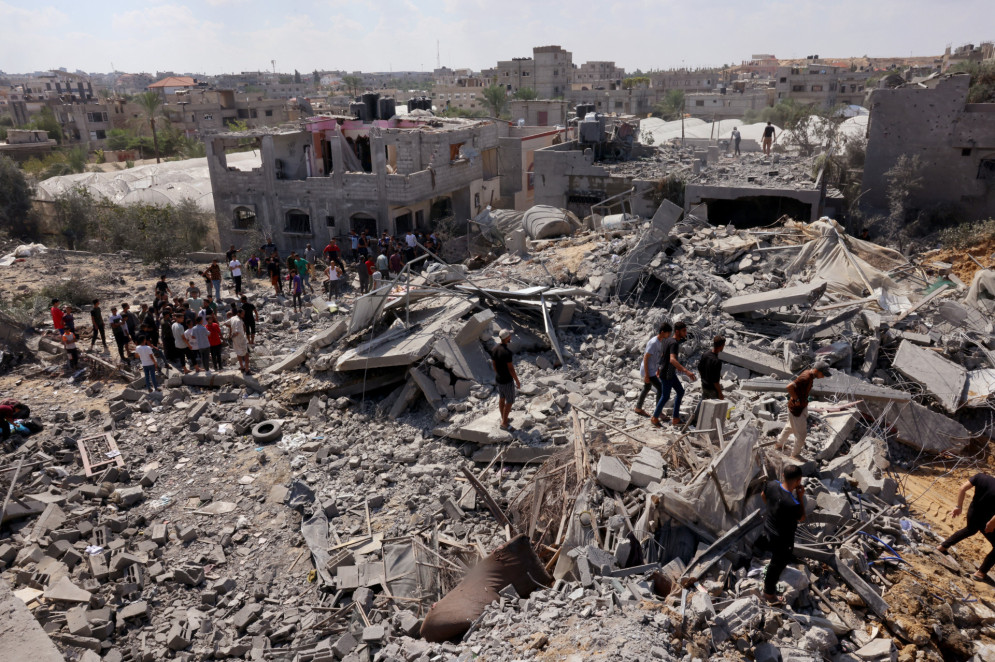 Palestinos vasculham os escombros de edifícios destruídos após um ataque israelense, enquanto as batalhas entre Israel e o movimento Hamas continuam pelo sexto dia consecutivo na cidade de Rafah, no sul da Faixa de Gaza, em 12 de outubro de 2023(Foto: SAID KHATIB / AFP)