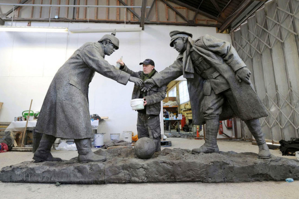 O escultor Andrew Edwards aplica os toques finais no monumento All Together Nos, em memória dos soldados que participaram do célebre jogo de futebol entre ingleses e alemães.  A obra foi apresentada ao público em dezembro de 2014, no aniversário de cem anos do jogo de futebol, e está no interior de uma igreja destruída por bombas durante a Primeira Guerra Mundial, em Liverpool(Foto: Reprodução Trucestatue.co.uk)