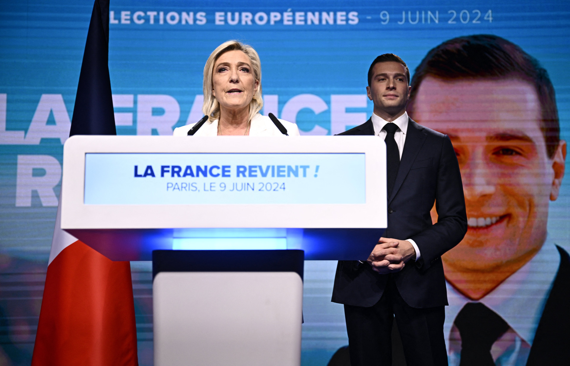 A líder do partido francês de extrema direita Rassemblement National (RN), Marine Le Pen (E), dirige-se aos militantes enquanto o presidente do partido, Jordan Bardella, ouve depois que o presidente francês anunciou que está convocando novas eleições gerais em 30 de junho(Foto: JULIEN DE ROSA / AFP)