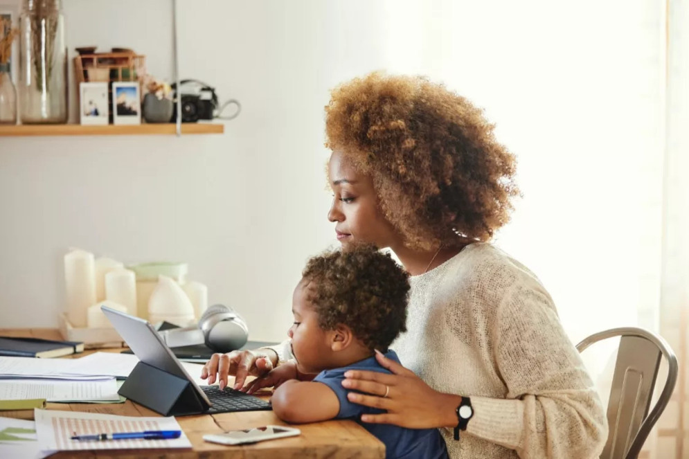 Mãe trabalhando com o filho no colo(Foto: Getty Images)