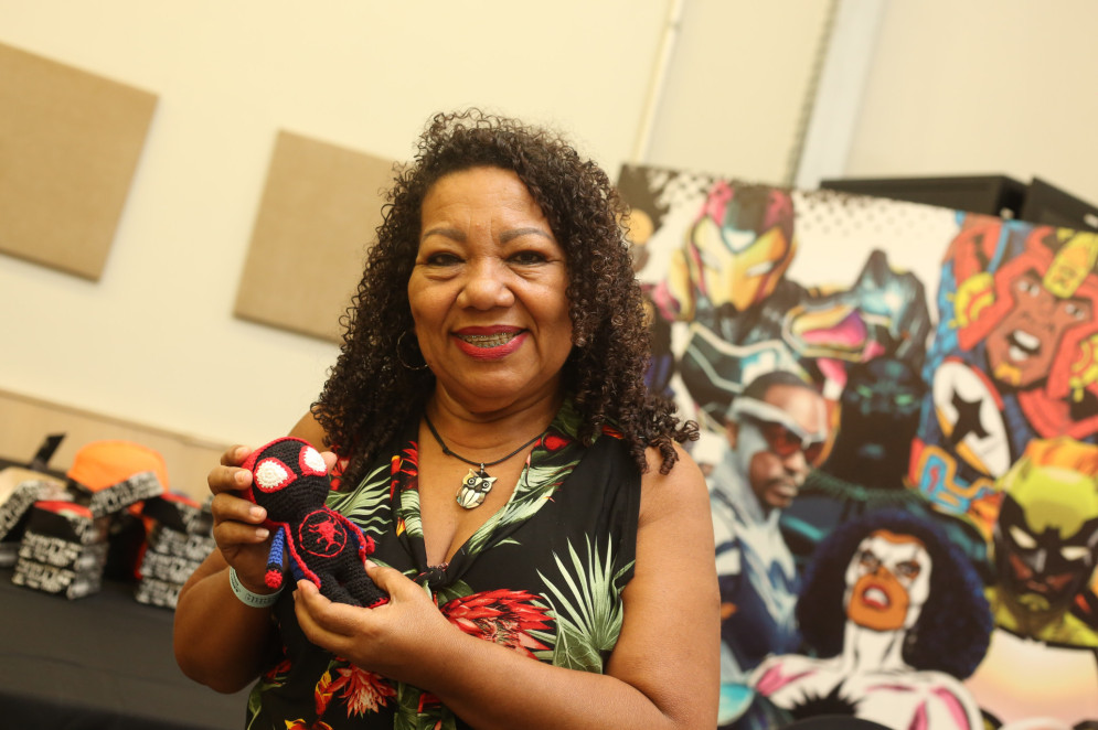 Dona Aldair, mãe de Danielle Alícia, exibe um de seus amigurumi vendidos no Sana 2024(Foto: Esdras / Sana)