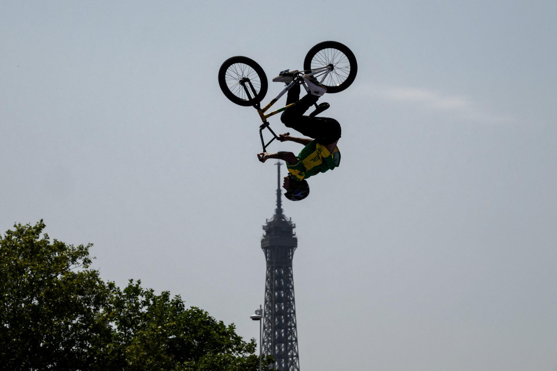 O brasileiro Gustavo Batista De Oliveira se aquece antes da qualificação masculina do Ciclismo BMX Freestyle Park com a Torre Eiffel ao fundo durante os Jogos Olímpicos de Paris 2024 em Paris, em 30 de julho de 2024.
 (Foto: JEFF PACHOUD / AFP)