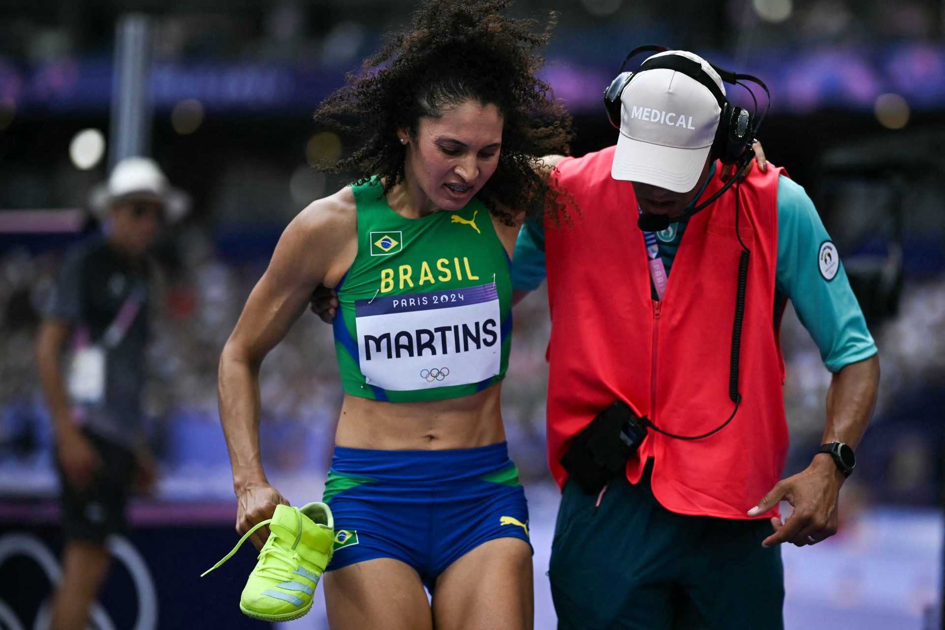 A brasileira Valdileia Martins recebe atendimento médico enquanto compete na qualificação do salto em altura feminino do evento de atletismo nos Jogos Olímpicos de Paris 2024, no Stade de France, em Saint-Denis, ao norte de Paris, em 2 de agosto de 2024. (Foto: Ben STANSALL / AFP)