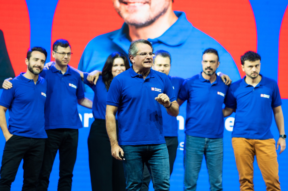 Jonas Marques, CEO da Pague Menos durante painel na Abrafarma. Ao fundo, os vice-presidentes Renato Camargo (Clientes), Luiz Novais (Financeiro e Relações Institucionais), Rosi Purceti (Gente, cultura e sustentabilidade), Carlos Fernandes (Operações), Robledo Castro (Tecnologia e informação) e Walace Siffert (Comercial e supply)(Foto: Cami de Almeida/ Divulgação)