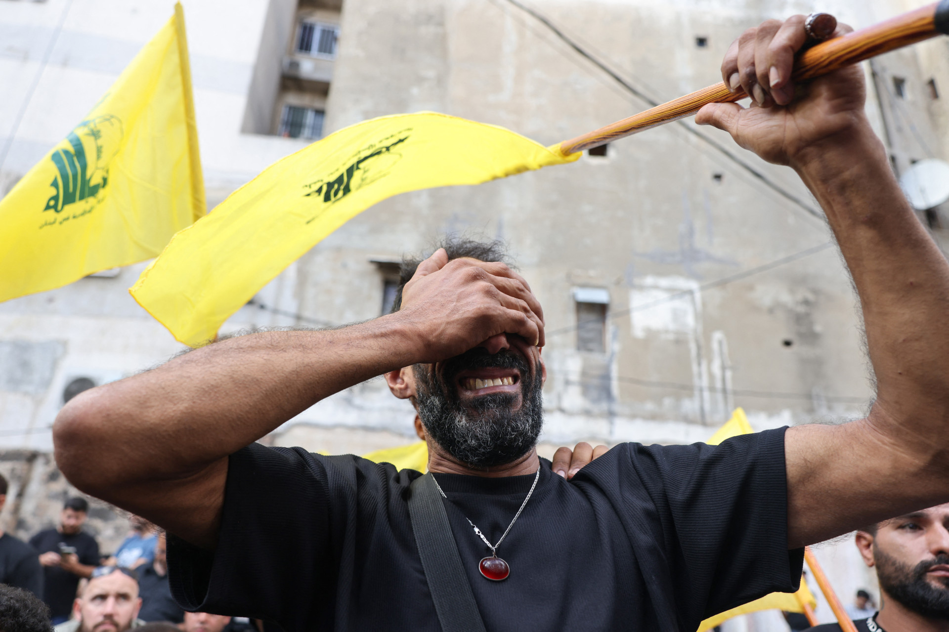 HOMEM com bandeira do Hezbollah em funeral após explosões dos pagers (Foto: ANWAR AMRO / AFP)