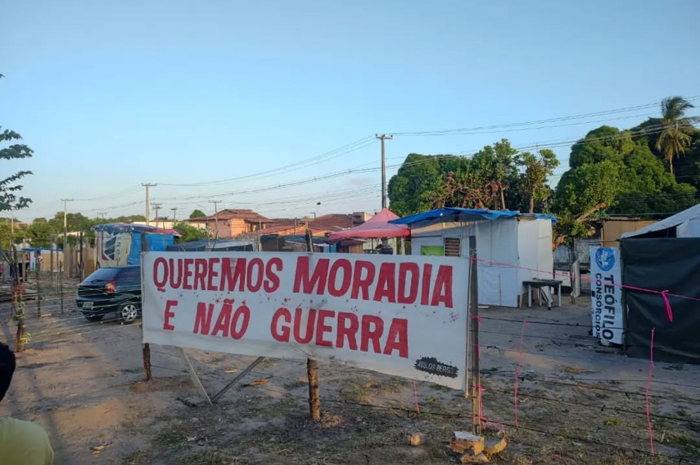 Placa afixada em frente à ocupação Heisenberg, no bairro Serrinha, divisa com Dias Macedo. Fica em um terreno da União cedido ao Governo do Estado ao lado da área verde afetada pelo PLC, local onde algumas ocupações irregulares também já se estabeleceram nos últimos anos(Foto: Acervo pessoal/Evangelista das Comunidades)