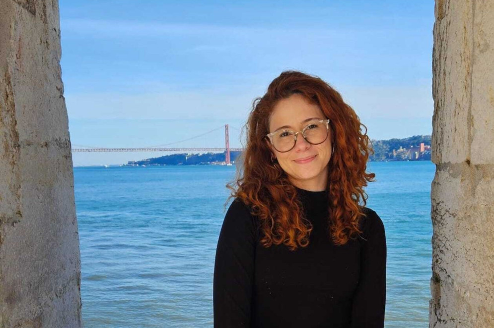 ParaTodosVerem: A imagem mostra Cecília Paiva, advogada do Escritório Frei Tito. Ela está sentada em frente ao mar. É uma mulher branca, tem os cabelos ruivos cacheados e usa óculos(Foto: Arquivo Pessoal/Cecília Paiva)