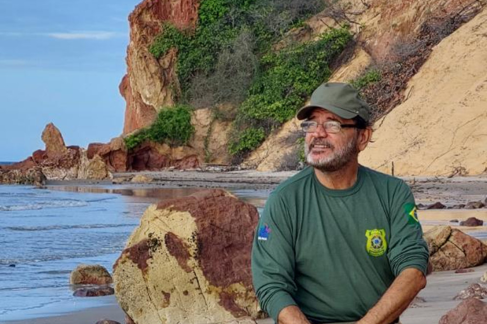 ParaTodosVerem: imagem mostra Juca Alencar, diretor de fiscalização do Ibama. Ele está em primeiro plano. Atrás está o mar. Usa um boné e camisas verdes(Foto: Arquivo Pessoal/Juca Alencar)