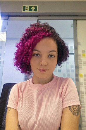 ParaTodosVerem: Joyce Oliveira é uma mulher com pele clara,cabelos cacheados, curtos, com a lateral esquerda tingida de rosa(Foto: Reprodução/ Arquivo pessoal)