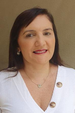 Evelynne Tabosa é uma mulher de cabelos castanhos escuros e lisos, usa blusa branca com botões e colar(Foto: Reprodução/ Arquivo pessoal)
