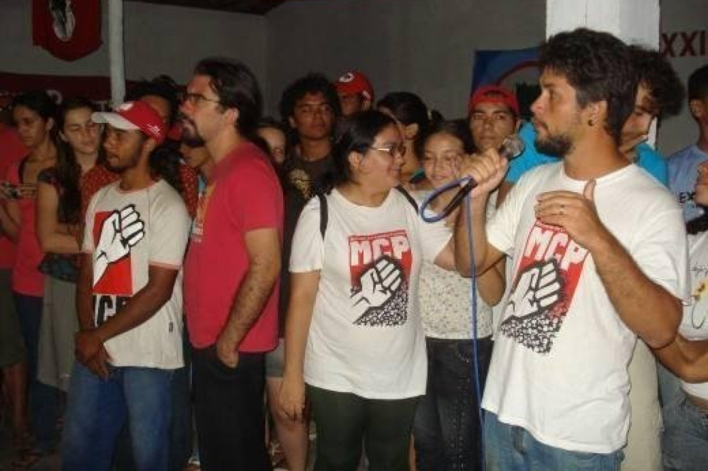 ParaTodosVerem: na imagem, há um grupo de pessoas com camisas do MCP. Sérgio aparece na lateral direita falando ao microfone(Foto: Reprodução/ Arquivo pessoal)