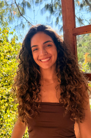 Jhennifer Oliveira Paula é uma jovem de pele parda e cabelos longos e cacheados em tom castanho cobre(Foto: Reprodução/ Arquivo pessoal)