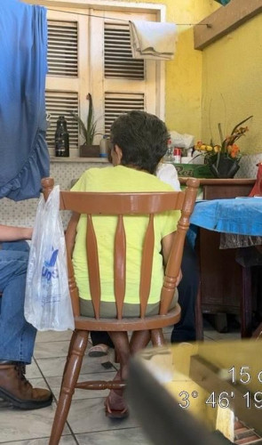 ParaTodosVerem: Carolina, de costas, no dia do resgate. É uma senhora de cabelo escuro, em uma cadeira. Está de roupa amarela(Foto: MPT/Arquivo do Processo)