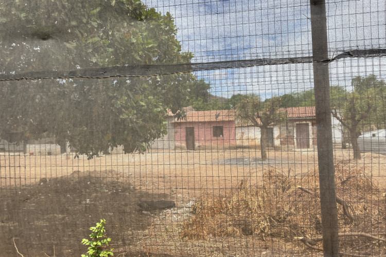 Casas dos moradores separadas por uma tela para se proteger da poeira(Foto: Fabiana Melo/O POVO)