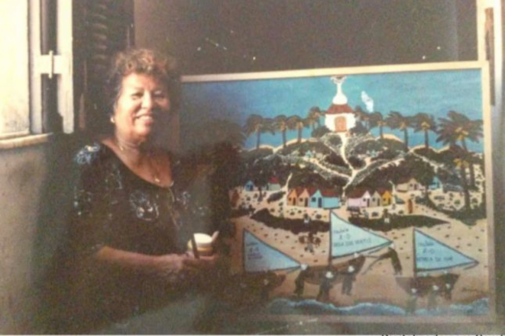 Considerada patrimônio vivo do Mucuripe, Mundinha posou ao lado de uma de suas telas e foi capa do jornal O POVO nos bairros em 30 maio de 1998(Foto: Acervo pessoal)